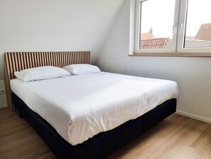 A bedroom with a bed, a window, and a sloped ceiling. - Holiday Home in Aagtekerke With Wi-fi (Aagtekerke)