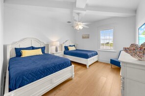A bedroom with two beds, a ceiling fan, a window with blinds, and a view of the outdoors. - X1114 Schefflera Ct 4 Bedroom Home (Captiva)
