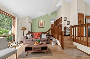 A living room with a sofa, coffee table, and a staircase.