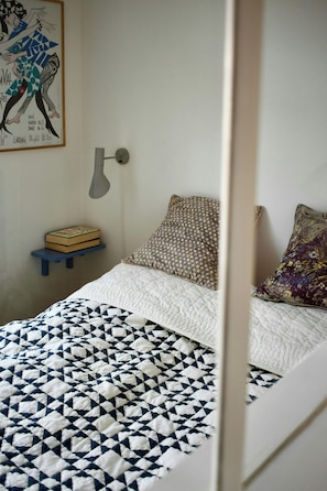 A bedroom with a bed, a nightstand, a lamp, and a framed picture on the wall. - Newly renovated flat with balcony in Nørrebro (København)