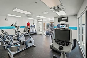 A gym with various exercise equipment, including treadmills and elliptical machines. - Bay Watch Condo with floor to ceiling windows | Bay Watch Resort - 1641 (North Myrtle Beach)