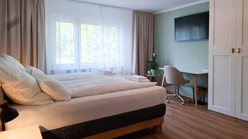 A bedroom with a bed, a desk, a chair, and a wardrobe.