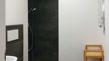 Ein modernes Badezimmer mit Toilette, Dusche und einem Holzregal.