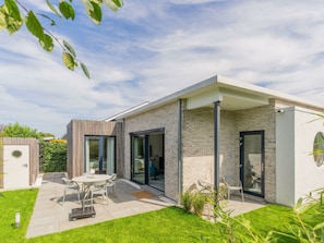 A modern house with a patio, a dining area, and a garage. - Holiday Home in Renesse With Swimming Pool (Renesse)