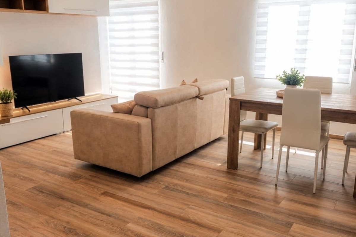 A modern living room with a sofa, a dining table, and chairs.