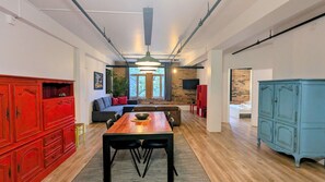 Ein zeitgemäßer Wohnbereich mit Essplatz, einer Couch und einem roten Schrank.