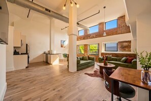 A spacious loft with a kitchen, dining area, and seating with a view of the outdoors. - The Garden Loft Near NYC + Parking + Patio (Kearny)