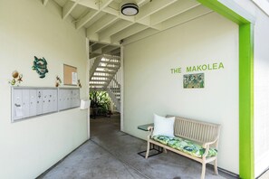A hallway with lockers, a bench, and a wall with 'THE MAKOLEA' signage.