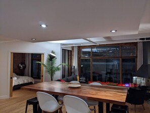A modern living room with a dining area, large windows, and a city view. - Stunning condo with a view, parking, and fireplace (Québec)