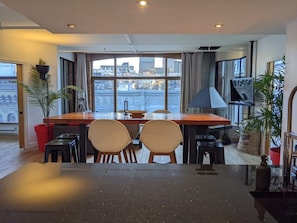 A modern kitchen with a dining area, large windows, and city views. - Stunning condo with a view, parking, and fireplace (Québec)