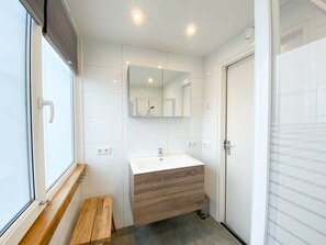 A modern bathroom with a white vanity, a mirror, and a bench. - Ok20 Holiday Home Oostkapelle (Oostkapelle)