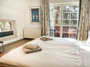 A bedroom with two beds, a window, a radiator, and a door leading to a balcony. - Holiday Apartment With 2 Bedrooms (Ostseebad Prerow)