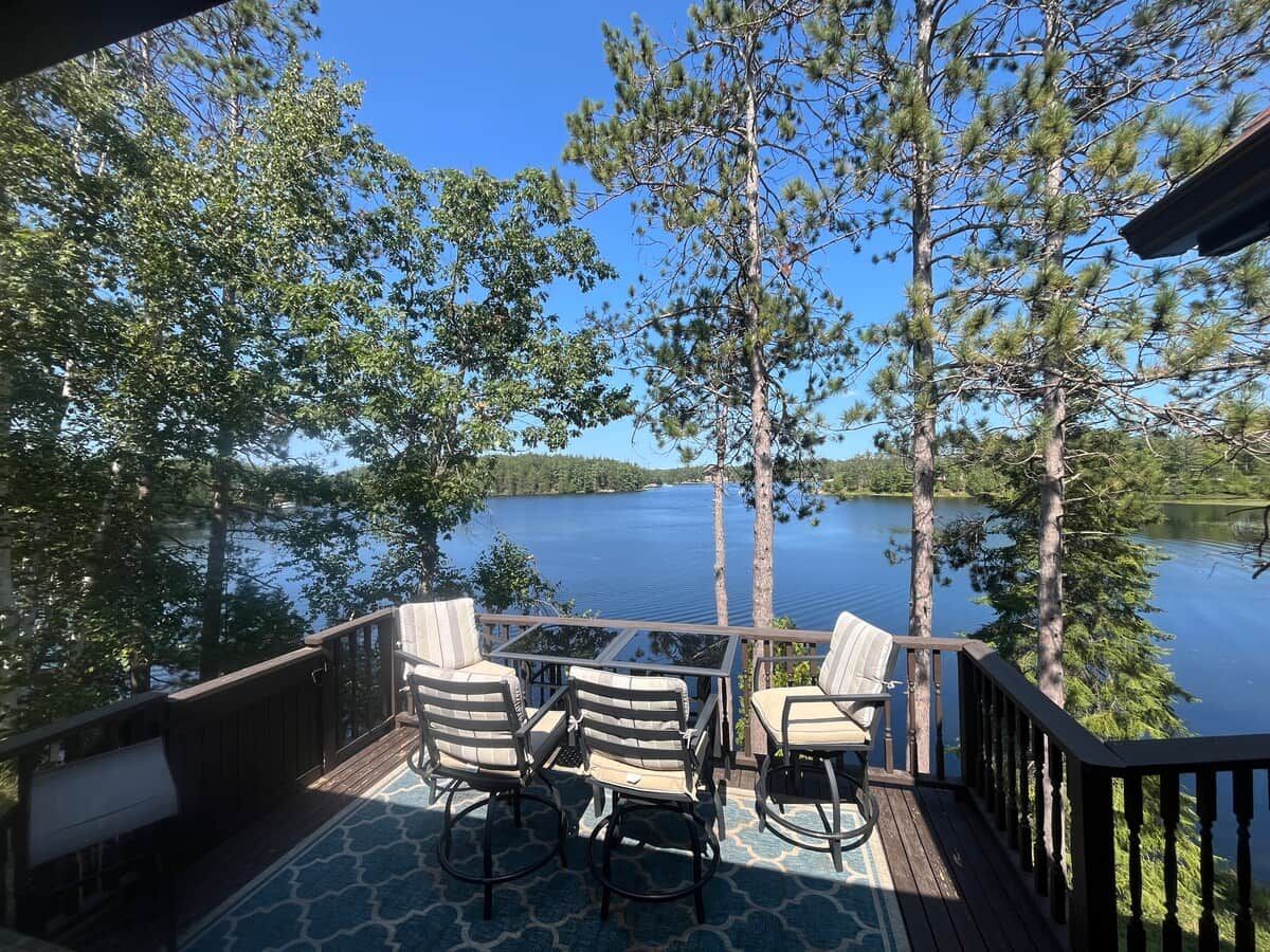 En terrass med utomhusmöbler och utsikt över en sjö.