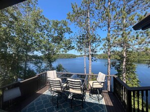 En terrass med utomhusmöbler och utsikt över en sjö.