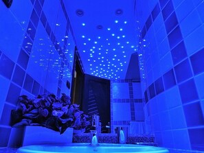 Ein Badezimmer im modernen Stil mit Waschbecken, Spiegel und einer Zimmerpflanze.