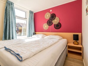Ein Hotelzimmer mit einem Bett, einem Nachttisch, einer Lampe und einer Wanddekoration.