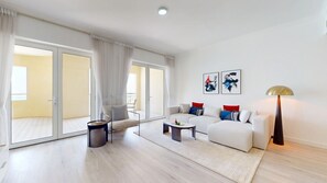 A modern living room with a sofa, armchair, coffee table, and floor lamp. - Spacious 2 Bed with Sea View in The Palm (Palm Jumeirah)