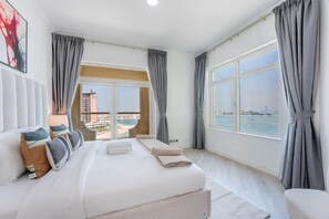 A hotel room with a large bed, a view of the sea, and a balcony. - Spacious 2 Bed with Sea View in The Palm (Palm Jumeirah)