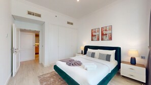 A hotel room with a bed, bedside tables, a wardrobe, and artwork on the wall. - Spacious 2 Bed with Sea View in The Palm (Palm Jumeirah)