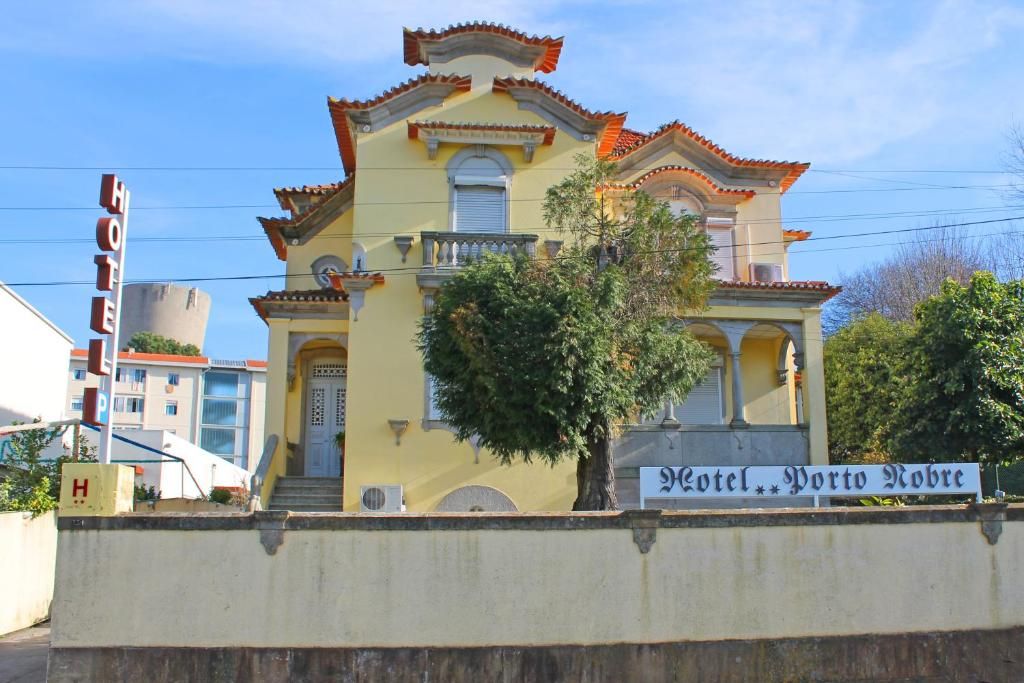 Un edificio amarillo con un letrero que dice 'Hotel Porto Novo'.