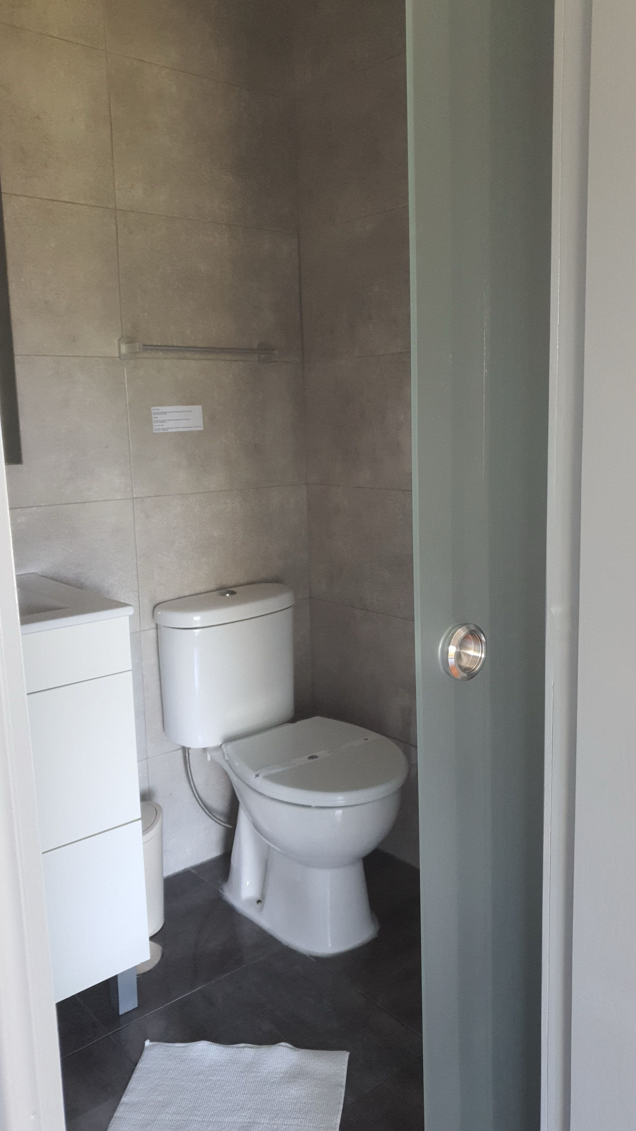 Une salle de bain comprenant des toilettes, un lavabo et un espace douche.
