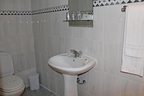 A bathroom with a white sink, toilet, and a towel rack. - HOTEL PORTO NOBRE (Porto)