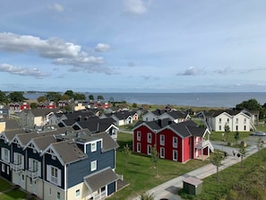 A coastal residential area with houses, a clear sky, and a view of the sea. - Holiday Apartment With 2 Bedrooms (Sierksdorf)