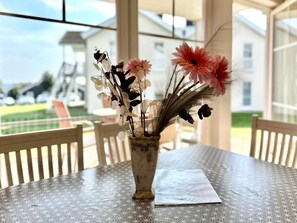 A table with a vase of flowers and a napkin. - Holiday Apartment With 2 Bedrooms (Sierksdorf)