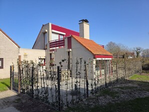 A residential building with a red roof, a chimney, and a balcony. - Vr03 Holiday Home Breezand With dog (Vrouwenpolder)