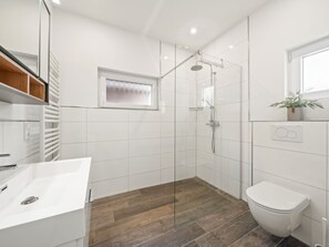A modern bathroom with a shower, toilet, and sink. - Holiday Home With 2 Bedrooms (Krummhoern)