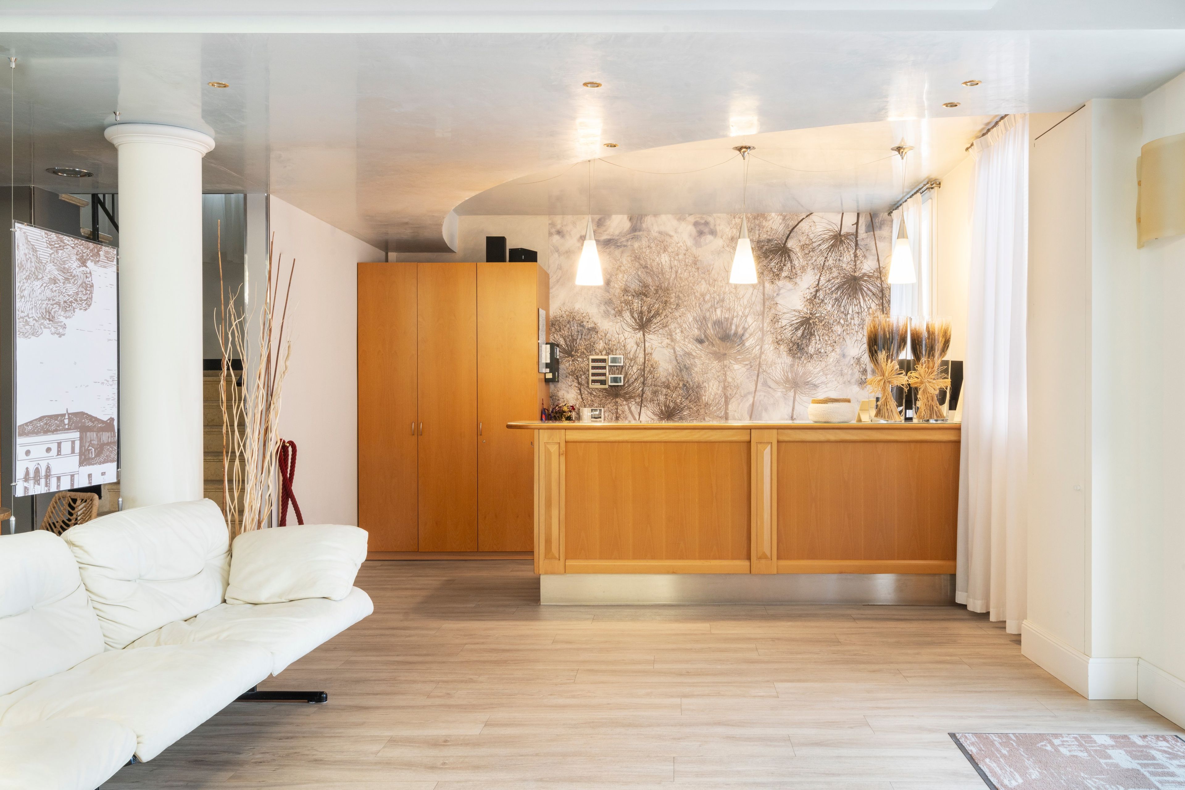 A modern kitchen with wooden cabinets, pendant lights, and a central island.