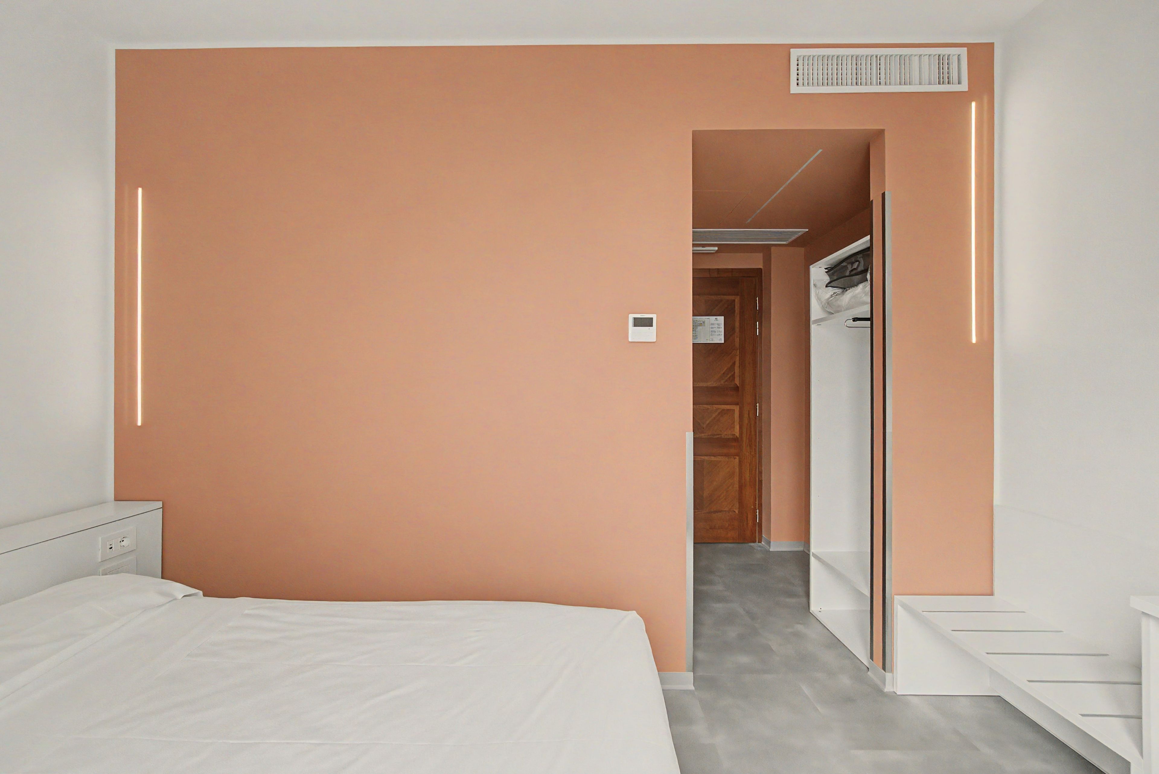 Un dormitorio con cama, armario y puerta que da a un baño.