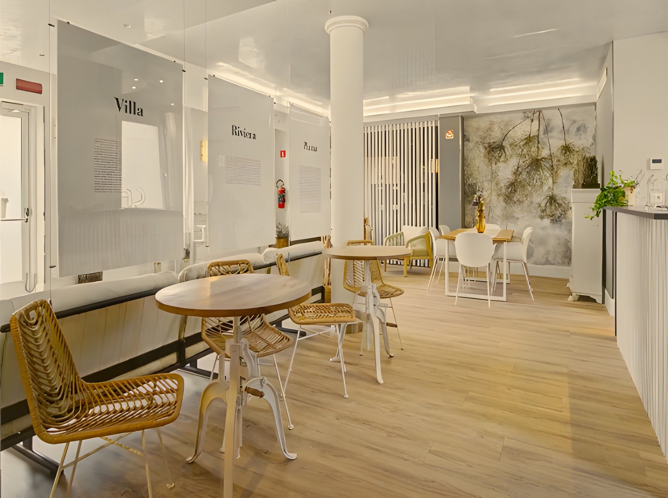 Un intérieur moderne avec des tables rondes et des chaises en osier, des murs blancs et un plancher en bois.