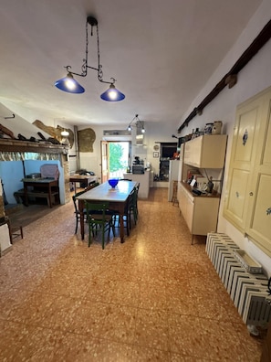 Une cuisine avec une table à manger, des chaises et des luminaires suspendus.