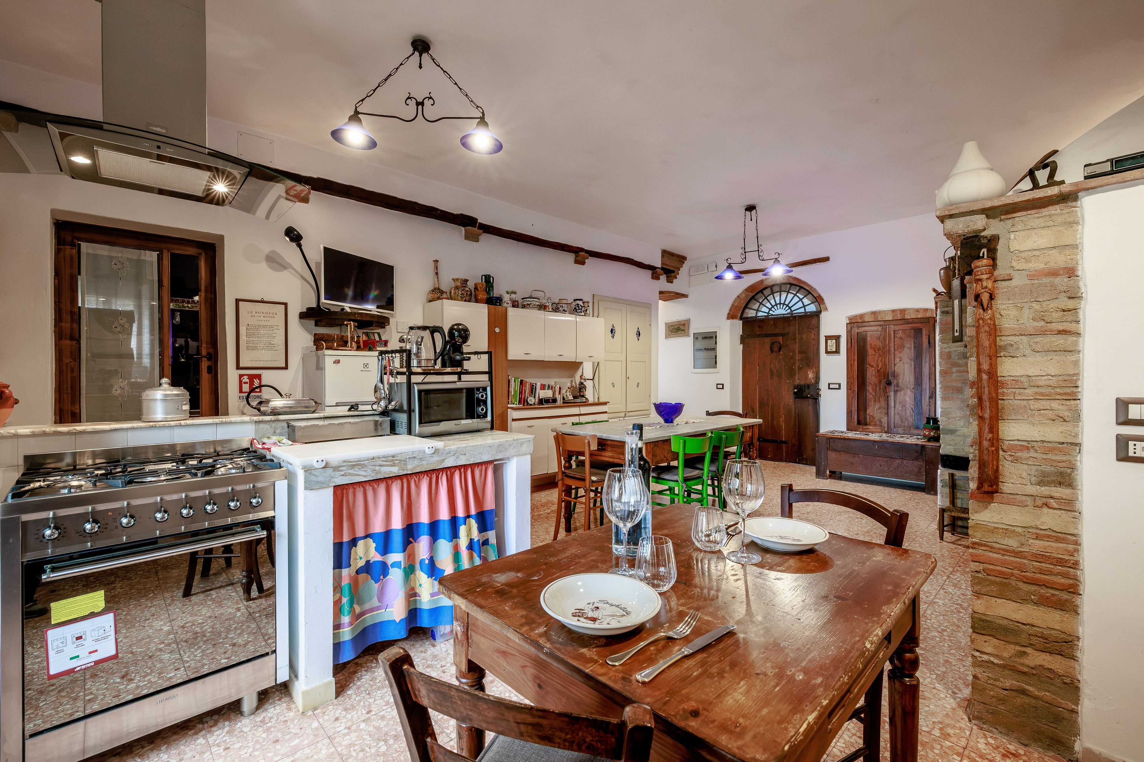 A spacious kitchen with a dining area, equipped with a stove, oven, microwave, and various kitchen appliances.