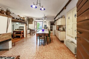 A kitchen with a dining area, wooden cabinets, and a tiled floor.