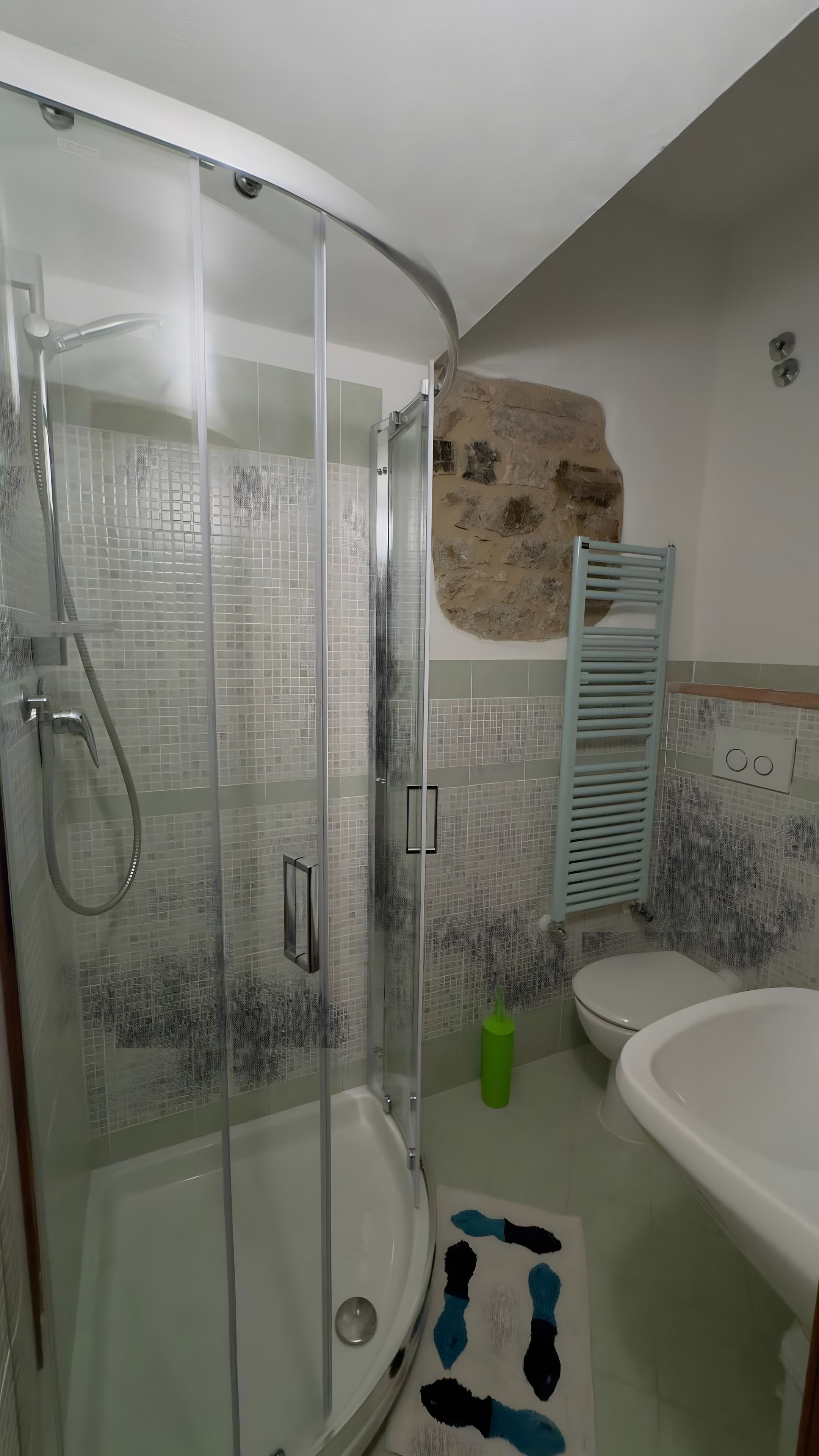 Une salle de bain avec une douche à parois de verre, des toilettes et un lavabo.
