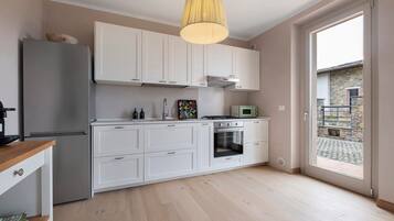 Une cuisine moderne avec des meubles blancs, un four encastré et un four à micro-ondes.