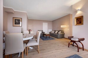 A living room with a dining area, a sofa, a coffee table, and a lamp.
