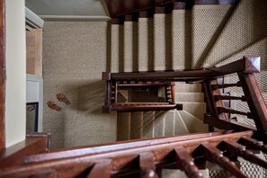 A wooden staircase with a textured wall behind it. - The Georgian House (Ludlow)