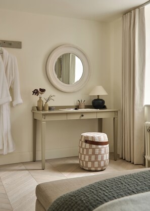 A bedroom with a bed, a bedside table, a mirror, a lamp, and a window with curtains. - The Georgian House (Ludlow)