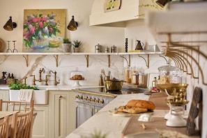 A kitchen with a marble countertop, a stove, and various kitchen items. - The Georgian House (Ludlow)