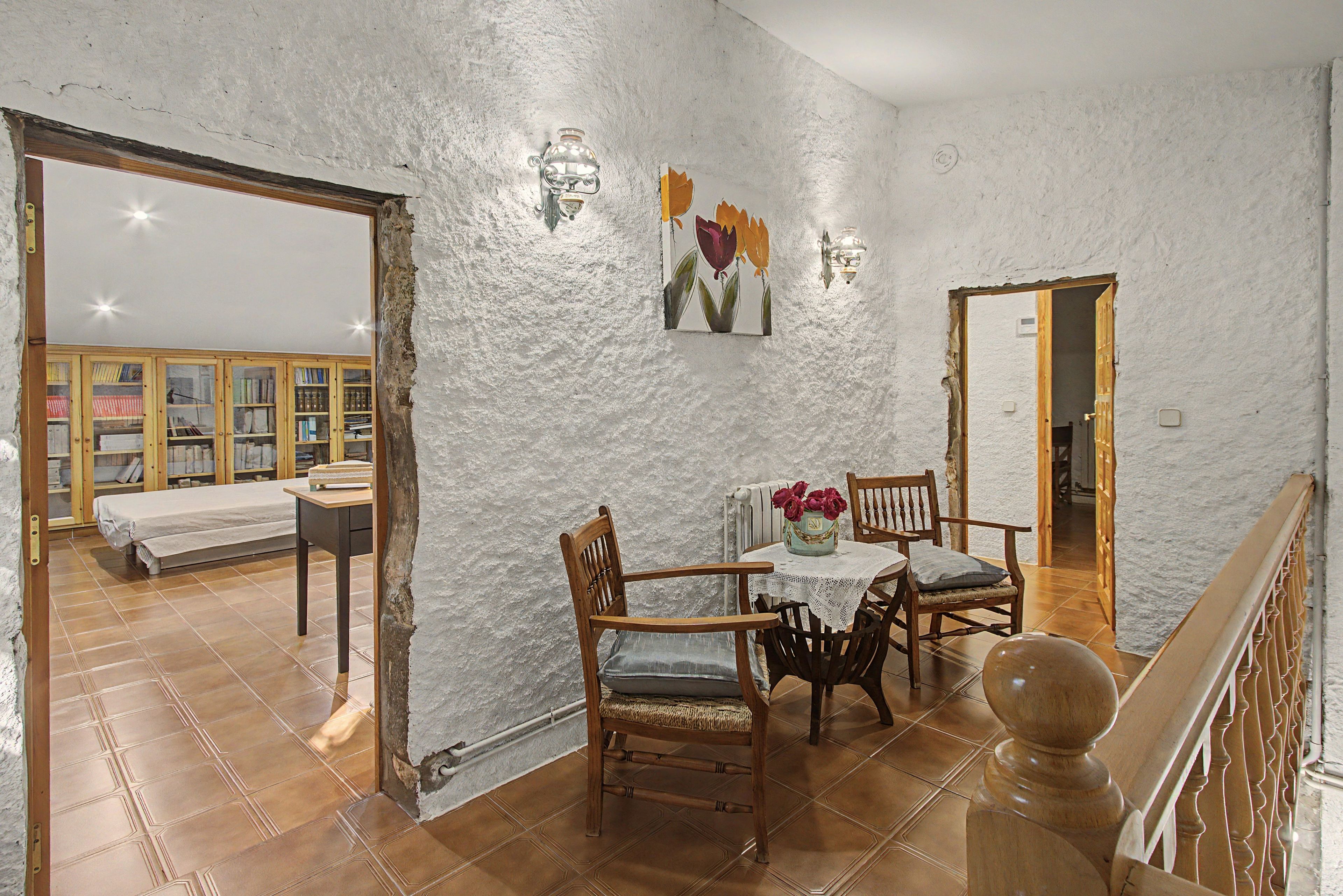 Un comedor con mesa, sillas y un florero.