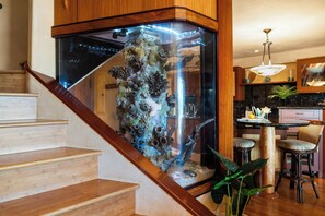 A staircase leading to a room with a large aquarium. - Expansive Ocean Views in Puamana 48-3 (Lahaina)