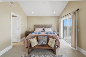 A bedroom with a bed, a nightstand, a dresser, a window with curtains, and a door. - Redington Beach Getaway  A Short Walk to the Gulf (Redington Beach)