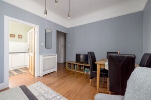 A modern living room with a dining area, a TV, and a fireplace. - 2 Bed Main Door Apt on Leith Walk, Near Tram (Edinburgh)