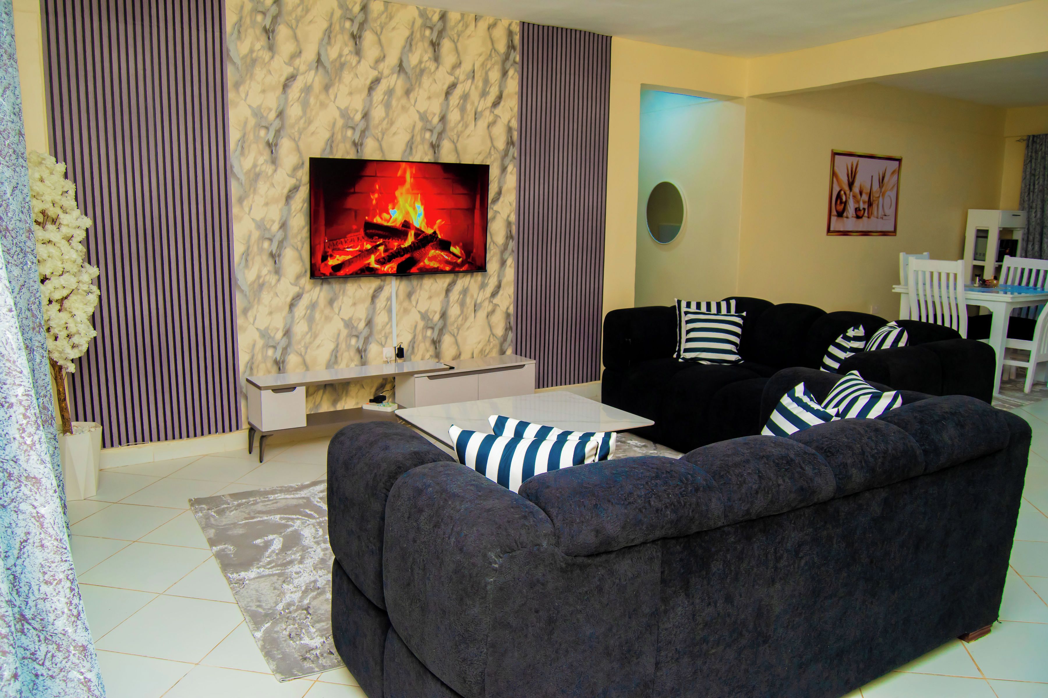 Una sala de estar con un juego de sofá, un televisor de pantalla plana y una chimenea.