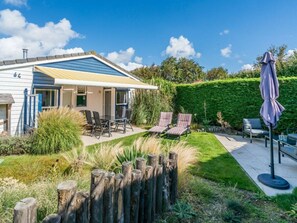 A house with a patio area featuring outdoor furniture and a covered seating area. - Holiday Home in Renesse With Swimming Pool (Renesse)
