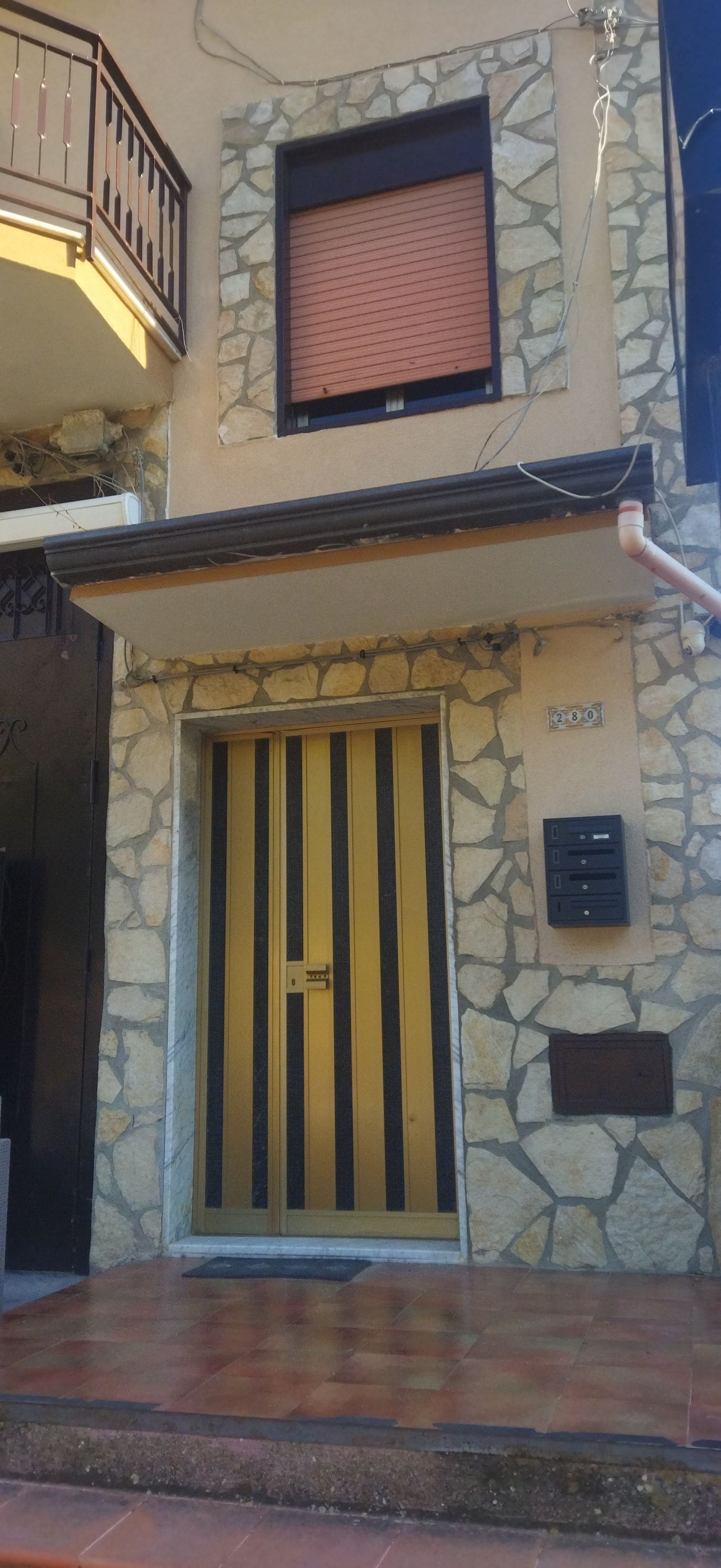 A building with a stone facade, a large barred entrance, and a small window above the door.