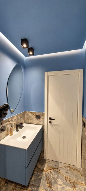 A bathroom with a large rectangular sink, a mirror, and a door. - Lungofiume Suite | Entire apartment with terrace, 3 bedrooms and 2 bathrooms (Avellino)